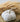 Textured grain sack fabric pumpkin decoration on a wooden surface with wheat stalks in the background