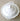 A white ceramic lidded serving dish with decorative handles and a raised knob on the lid, photographed from above on a beige textured fabric background.