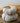 Textured beige grain sack fabric pumpkins stacked on a wooden surface with a blurred background