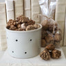 A white cheese mold filled with keya pods. Fall decorating vignette.