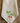 A cream-colored linen kitchen towel with embroidered green leaves and raspberry motif, laid flat on a rustic wooden surface.